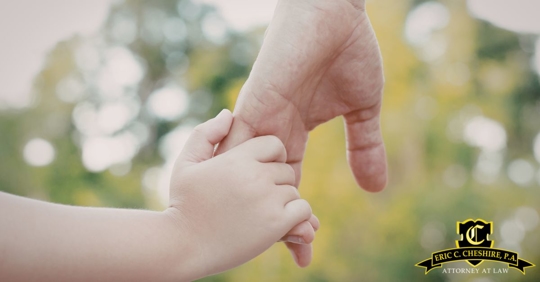 person holding their child's hand